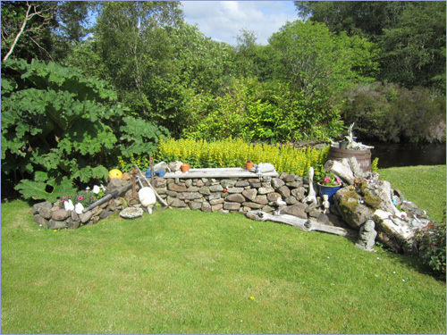 A landscaped stone water feature set among the planting in the garden at Carrick.